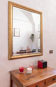 ein Spiegel auf einem Tisch mit zwei Gläsern und einem Radio in der Unterkunft Sweet Home Pitti in Crema