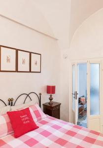 a bedroom with a bed with a red and white checkered blanket at Sweet Home Pitti in Crema