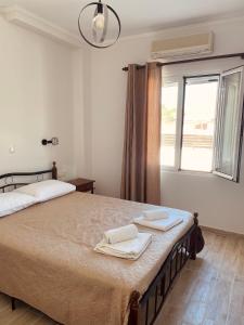 a bedroom with a large bed with two towels on it at Angelos Apartments in Lixouri