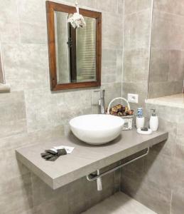 a bathroom with a sink and a mirror at La Casa all'Oliveto in Pitigliano