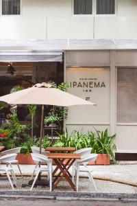 een tafel en stoelen met een parasol voor een gebouw bij Ipanema Inn Hotel in Rio de Janeiro