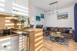a kitchen and living room with a couch and a table at Blue Wave Apartment by Renters in Ustronie Morskie