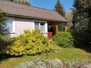 una casa con un porche y un arbusto delante de ella en Erdőszéli vendégház, en Dudar