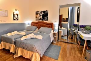1 Schlafzimmer mit 2 Betten, einem Tisch und einem Spiegel in der Unterkunft DolceVeneto Rooms & Suites in Rom