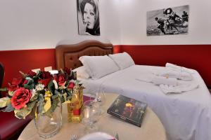 una camera con due letti e un tavolo con fiori di DolceVeneto Rooms & Suites a Roma