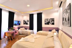 ein Hotelzimmer mit 3 Betten und einem Tisch in der Unterkunft DolceVeneto Rooms & Suites in Rom