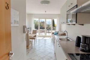 a kitchen with a sink and a living room at Residence Roland in Caldaro
