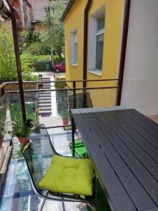 a balcony with a table and a green seat at Guest House Pavlovic in Soko Banja