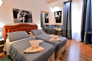 ein Schlafzimmer mit 2 Betten und Handtüchern darauf in der Unterkunft DolceVeneto Rooms & Suites in Rom