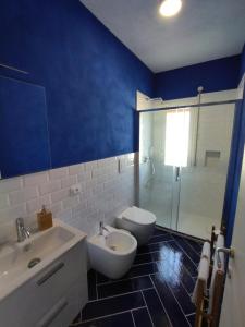 bagno blu con servizi igienici e lavandino di Casa Vacanze Playa 54 a Castellammare del Golfo