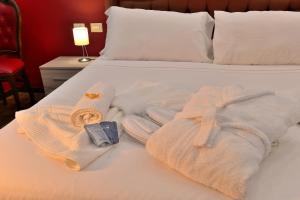 Una cama con toallas y una bata. en DolceVeneto Rooms & Suites, en Roma