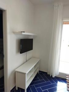 a room with a white desk with a tv on a wall at Casa Vacanze Playa 54 in Castellammare del Golfo