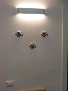 een licht op een muur met vier platen erop bij Casa Vacanze Playa 54 in Castellammare del Golfo