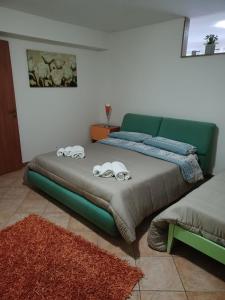 een slaapkamer met een groen bed met twee telefoons erop bij CASA ORCHIDEA in Carlentini