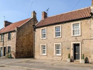 uma velha casa de tijolos ao lado de uma rua em Deanery View em Darlington