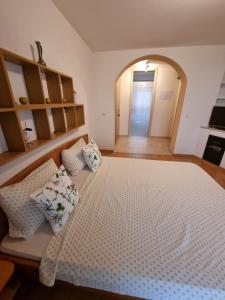 a bedroom with a large bed with pillows on it at Guest House Suzana in Omišalj