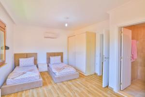 a bedroom with two beds and a closet at Kuytu Kaş Houses in Kas