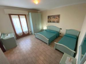 Habitación pequeña con 2 camas y ventana en Country House Tenuta Fornacelle, en San Gimignano