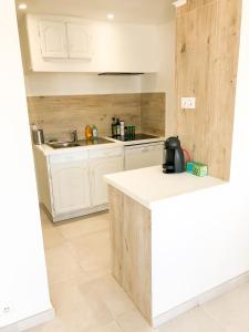 Una cocina con gabinetes blancos y encimera. en Appartement la Frégate avec terrasse à 100m de la plage, en Saint-Cyr-sur-Mer