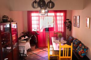 a dining room with a table and a red door at Pousada Montanha Sagrada in São Lourenço