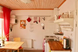 uma cozinha com um lavatório e uma mesa num quarto em Bed & Breakfast Björkhyddan em Rumma