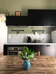 uma cozinha com uma mesa com um vaso de flores em La cabane de la mare - Meublé de tourisme 3 étoiles em Précy