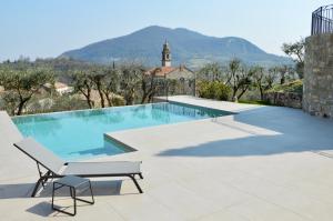 a swimming pool with a bench and a chair at Borgo Petrarca in Arquà Petrarca