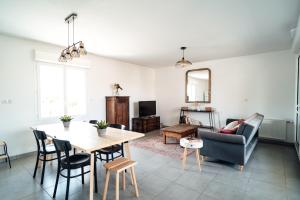 a living room with a table and a couch at SEAHORSE - Spacieux Appartement proche du port de la Teste in La Teste-de-Buch