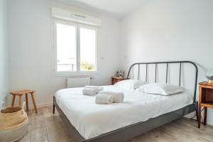 a bedroom with a bed with white sheets and pillows at SEAHORSE - Spacieux Appartement proche du port de la Teste in La Teste-de-Buch