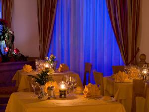 a dining room with two tables and blue curtains at Domina Parco Dello Stelvio in Cogolo