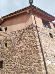 a street light on the side of a stone building at Casa Sorianna in Montenegro de Cameros