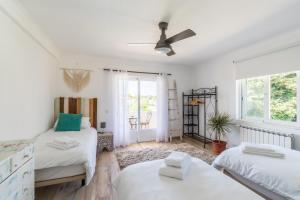une chambre avec deux lits et un ventilateur de plafond dans l'établissement Vida Boa Lodge, à Lagos