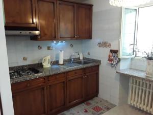 a kitchen with wooden cabinets and a sink and a window at Le Jasmin da Marina in Saint Vincent