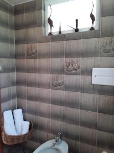 a bathroom with a toilet and a basket of towels at Le Jasmin da Marina in Saint Vincent +49 photos