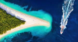 an aerial view of a beach with a boat in the water at Zlatni Rat Beach Resort in Bol
