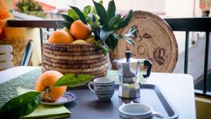 a table with a basket of oranges and a juicer at Casa Sisina in Flussio