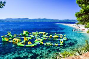 a group of water slides in the water on a beach at Zlatni Rat Beach Resort in Bol