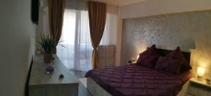 ナボダリにあるGarsonieraのベッドルーム(紫色のベッド1台、窓付)