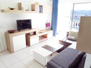 プラヤ・デル・クーラにあるMonseñor Ocean View Apartmentのリビングルーム(テレビ、ソファ付)