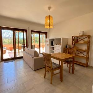 een woonkamer met een tafel en een bank bij SeaSun Guest House Alghero in Alghero