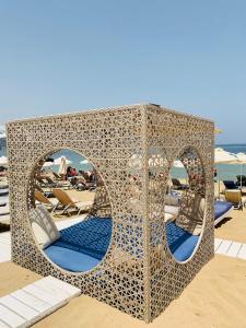 einer Wellen-Metallstruktur am Strand mit Stühlen in der Unterkunft Pleasure Beach Hotel in Malia
