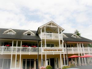 ein großes weißes Gebäude mit einem Schild darauf in der Unterkunft Dünenpark Binz - Komfort Ferienwohnung mit 1 Schlafzimmer und Balkon im Dachgeschoss 236 in Binz