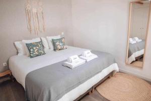 a bedroom with a large bed with towels on it at Casa dAmélia in Leiria