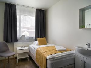 a bedroom with a bed and a sink and a mirror at Salt Guesthouse in Siglufjörður