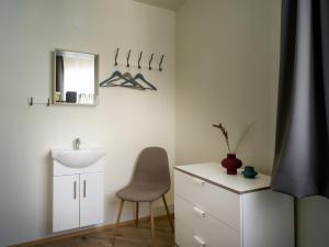 a bathroom with a sink and a chair and a mirror at Salt Guesthouse in Siglufjörður