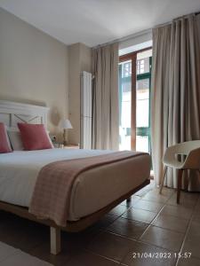 1 dormitorio con 1 cama grande con almohadas rojas en Apartamento Campomanes, en Villaviciosa