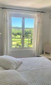 a bedroom with a bed and a large window at Charmantes Haus im Golf Club Saint Tropez in Saint-Tropez