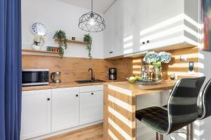 a kitchen with white cabinets and a wooden counter top at Blue Wave Apartment by Renters in Ustronie Morskie