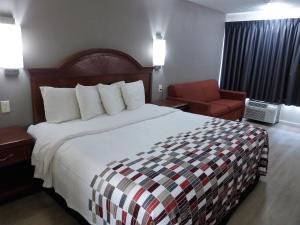 a hotel room with a large bed and a chair at Red Roof Inn Walton - Richwood in Richwood