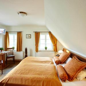 ein Schlafzimmer mit einem Bett mit orangefarbener Bettwäsche und Kissen in der Unterkunft Hotel Hof Tütsberg in Behringen